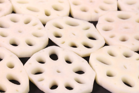 Lotus root slices on black background, close upの写真素材