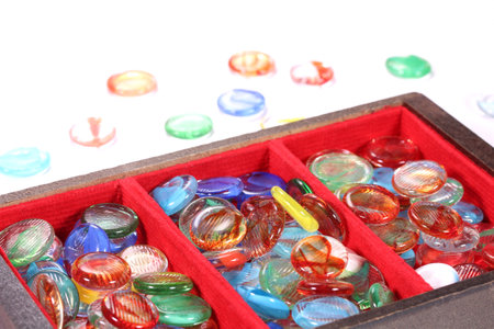 Colorful glass marbles in a wooden box on white background, close upの写真素材