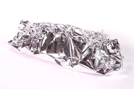 Foil grilled on white background ( ingredients wrapped in aluminum foil )の写真素材