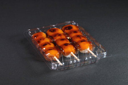 Japanese sweets Mitarashi dango in a plastic pack on black background.の写真素材