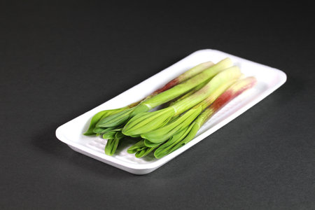 Ascetic garlic on a tray on black backgroundの写真素材
