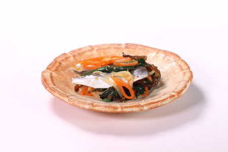 Pickled Mamakari ( Japanese sardinella ) with vegetables on a plate on white background.の写真素材