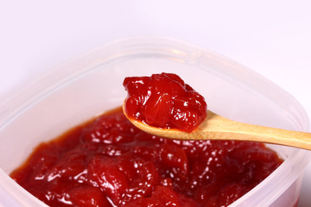 Scooping homemade watermelon jam with a wooden spoonの写真素材