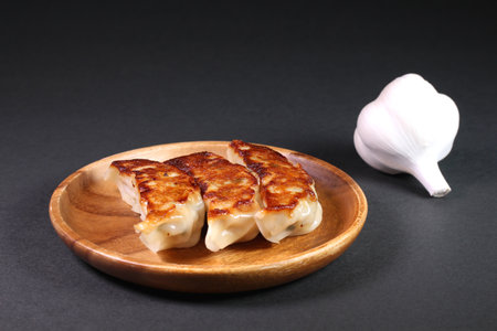 Fried dumplings and garlic on black backgroundの写真素材