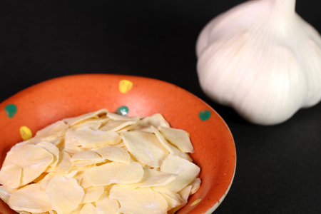 garlic and sliced ââgarlic on black backgroundの写真素材