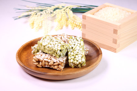 Japanese sweets Okoshi (puffed rice) on a plate and rice in a wooden boxの写真素材