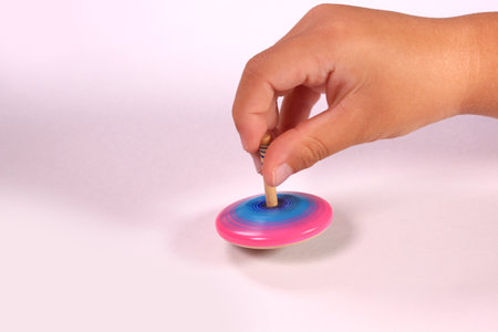 Child's hand playing with spinning topの写真素材