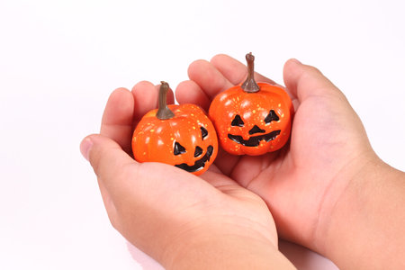 Child's hands holding haunted pumpkin decorationsの写真素材