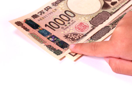 Child's hand pointing to the new 10,000 yen bill