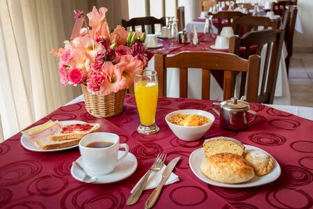 Classic breakfast based on coffee, bread, cold meats, orange juice, cake portion, cereals and meatloafの写真素材