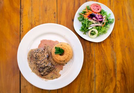 Steak au poivre or Pepper Steak served with quinoa and a fresh saladの写真素材