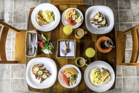 Full American Breakfast with coffee, orange juice, fresh fruits, eggs and french toasts for twoの写真素材