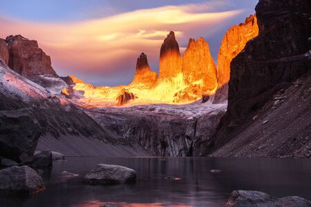 Torres del Paine from the base of the main peaks, below you can see the calm water of the lake. The sunrise overwhelm the peaks. Chile, Patagoniaの写真素材