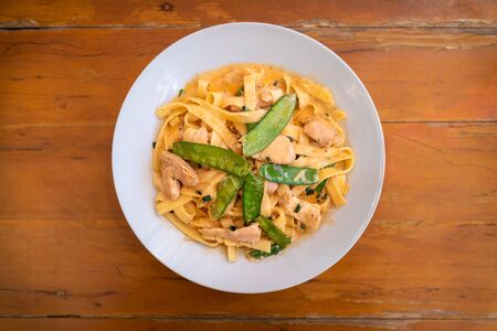 Tagliatelle with a Thai-Peruvian Salsa served with chickenの写真素材