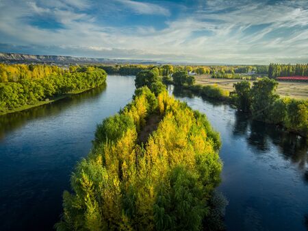 Aerial photography of a valley with a river in autumn. The yellow color is observed in the vegetation, there is a huge river divided in two. General Roca, RÃ­o Negro - Patagonia Argentinaの写真素材