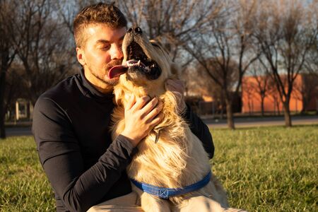 A man hugging his pet, a golden retriever dog. They look happy, tender and loving photography