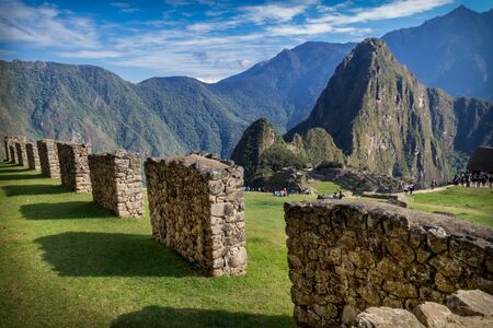 Machu Picchu archeological site from the inside. Big walls made of stones and some tourists can be seen. Peru, South Americaの写真素材