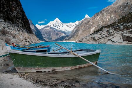 Old boat in the coast of the beautiful Lake Paron. Behind you can see the Piramide Mountain. Cordillera blanca of The Andes, Huascaran National Park, Peru.の写真素材
