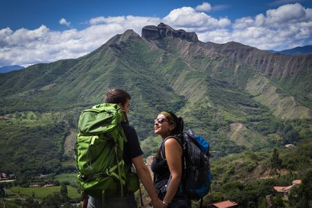 Backpacker couple holding hands surrounded by a natural landscape. Vilcabamba, Ecuadorの写真素材