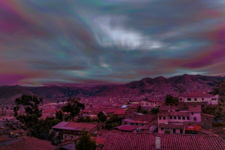 Beautiful violet-pink sunset in Cusco city. Taken from a viewpoint of the Historical center, there are some typical houses and big mountains behind. Peruの写真素材