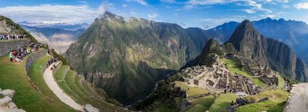 Amazing panoramic view of Machu Picchu ruins in Peru. Behind we can appreciate big and beautiful mountains full of green vegetation.の写真素材