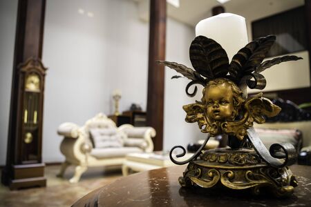 Living room in reception of a hotel where you can appreciate several antique objects of decoration such as a clock, armchairs and a bronze chandelierの写真素材