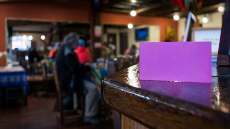 Small sign to complete information in a breakfast bar. Unfocused dinning room background with peopleの写真素材