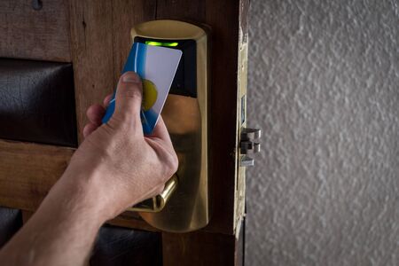 Man's hand using a security card to enter a hotel roomの写真素材