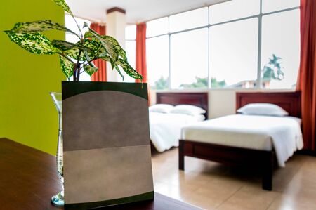 Blank advertising poster inside a hotel room. There are two beds and a large windowの写真素材