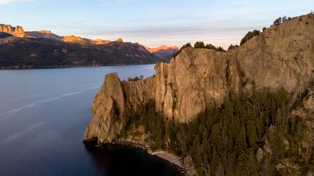 Lake Traful in Patagonia, Argentina. There is a rocky mountain and many pine trees sorrounding the lakeの写真素材