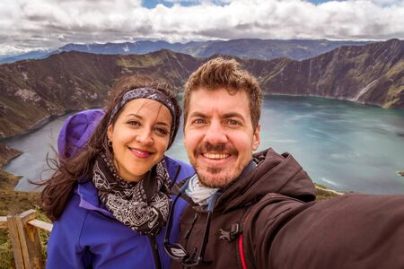 Couple of turists taking a selfie in the Quilotoa lagoon. Ecuador, South Americaの写真素材