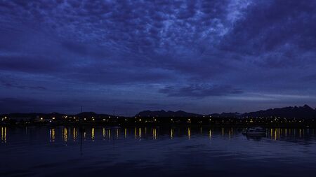 Beautiful landscape of the ocean at night. You can see many lights and boats on the pier or dock. Patagoniaの写真素材