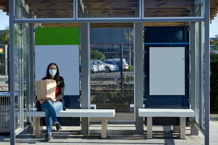 Young man wearing face mask standing in the middle of the road on an empty city centre. Coronavirus conceptの写真素材