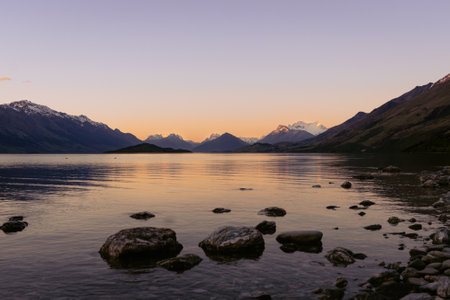 Dramatic sunset in Lake Wakatipu with the amazing view of snowy peaks. Otago, New Zealand.の写真素材