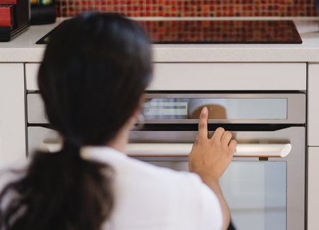 Woman touching screen in modern oven to cook. Technological concept.の写真素材