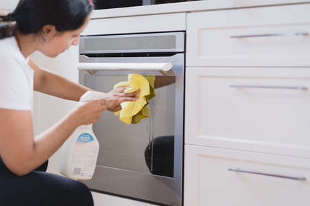 Woman cleaning modern kitchen with antiseptic to prevent virus.の写真素材