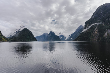 Milford Sound fjords on a cloudy day seen from a cruise. Fiordland National Park, New Zealand.の写真素材