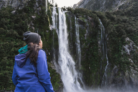Young woman admiring falls in Milford Sound. New Zealand travel destination.の写真素材