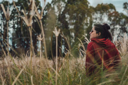 Young woman standing in the middle of rushes on rural area. Copy Space. Inspirational conceptの写真素材