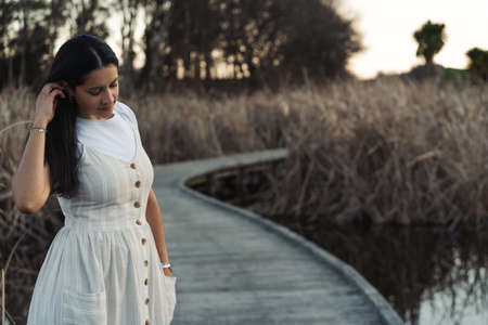 Brunette woman wearing dress looking pensive on outdoor autumn environment. Copy Space Portraitの写真素材