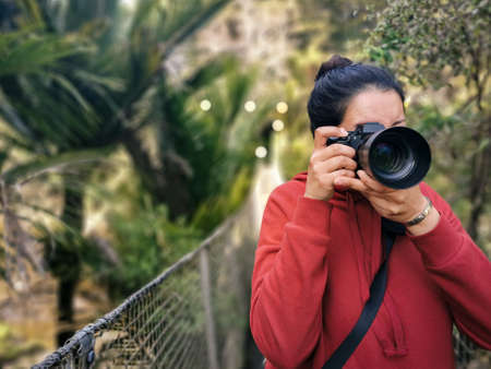 Young woman photographer holding digital professional camera. Copy-spaceの写真素材