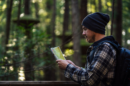 Young man looking at map in the middle of rainforest. Travel and tourism concept.の写真素材