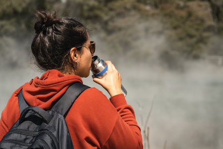 Woman drinking water while touring in hot pools at Kuirau Park. Rotorua, New Zealand.の写真素材