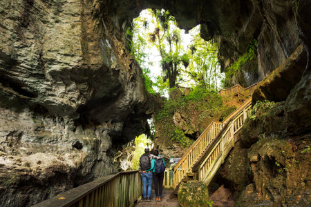 young couple embracing each other while admiring natural caves. Travel couple conceptの写真素材