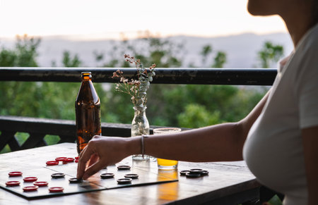 Playing draft on a balcony, a woman is making a movement. Close upの写真素材