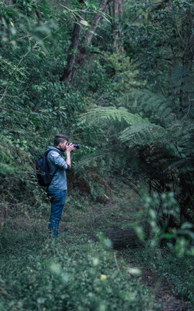 Caucasian photographer taking photos in the middle of the forest. portrait photographyの写真素材