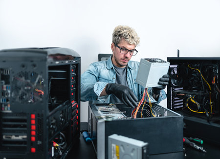 Caucasian young technician repairing inside of desktop computer cabinet. white backgroundの写真素材