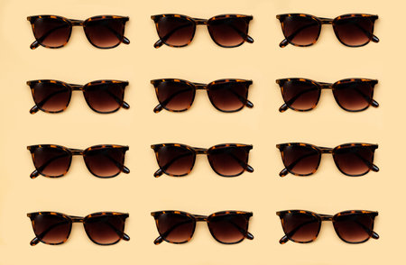 Brown sunglasses pattern on yellow background. top viewの写真素材