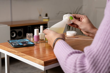 Woman using nail polish remover while doing manicure at home. Close up pictureの写真素材