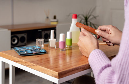 Woman files her thumb in manicure session at home. Close up pictureの写真素材